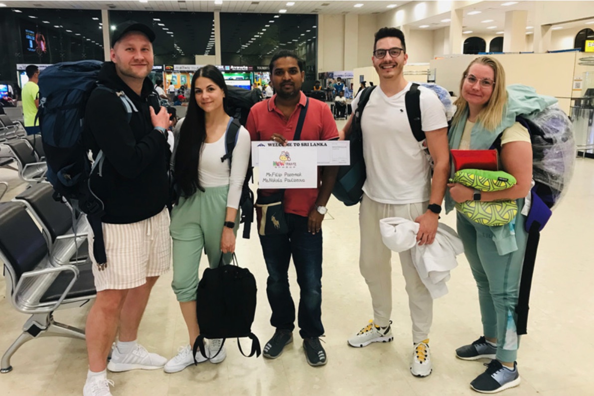 Four travellers meeting their private driver with luggage at Colombo airport