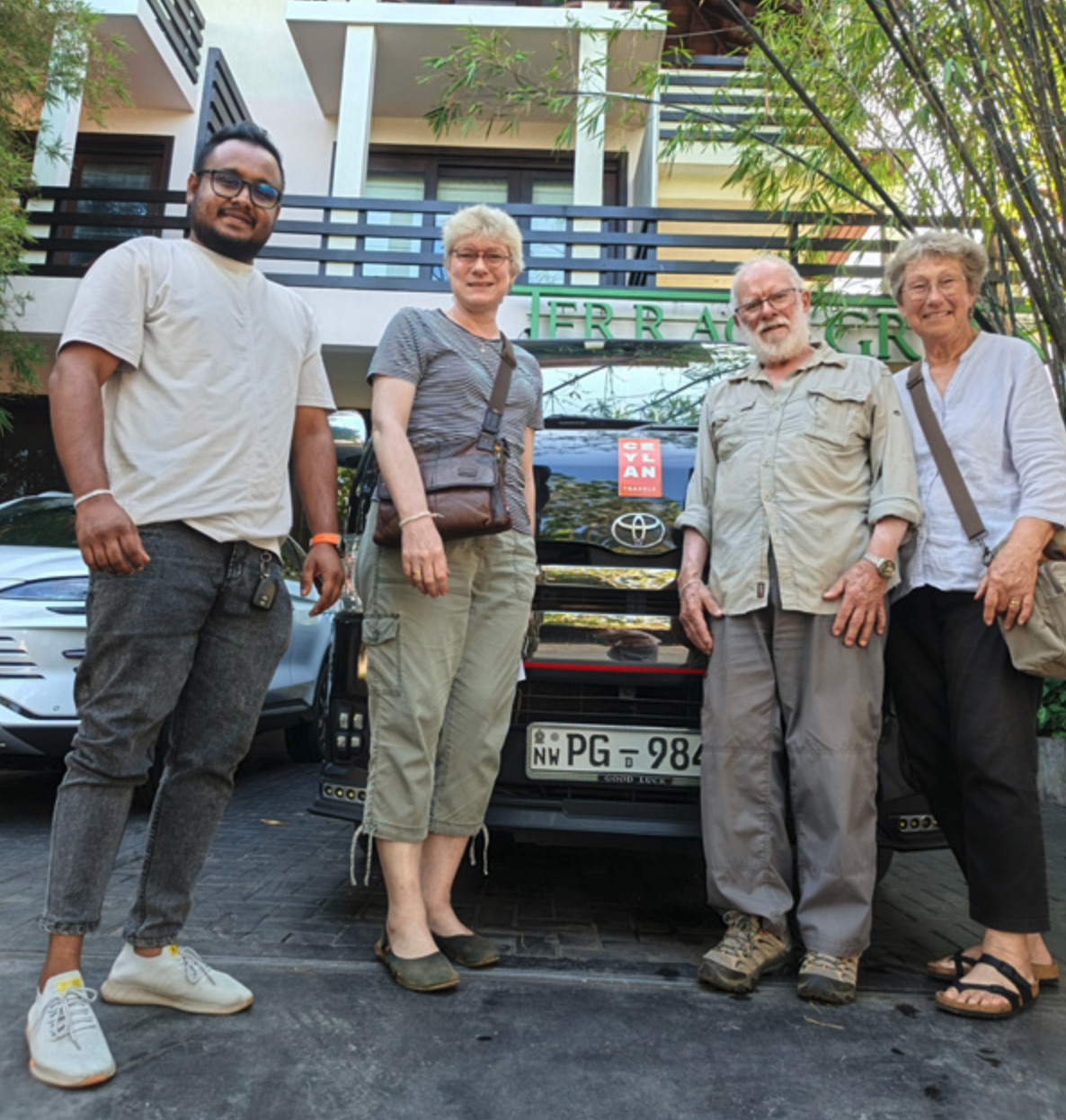 Senior travellers with their private driver beside a black charter vehicle in Sri Lanka