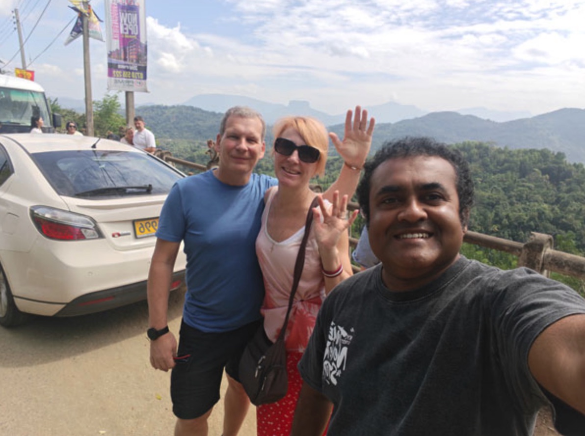 A couple with their private driver and charter car at a Sri Lanka mountain viewpoint
