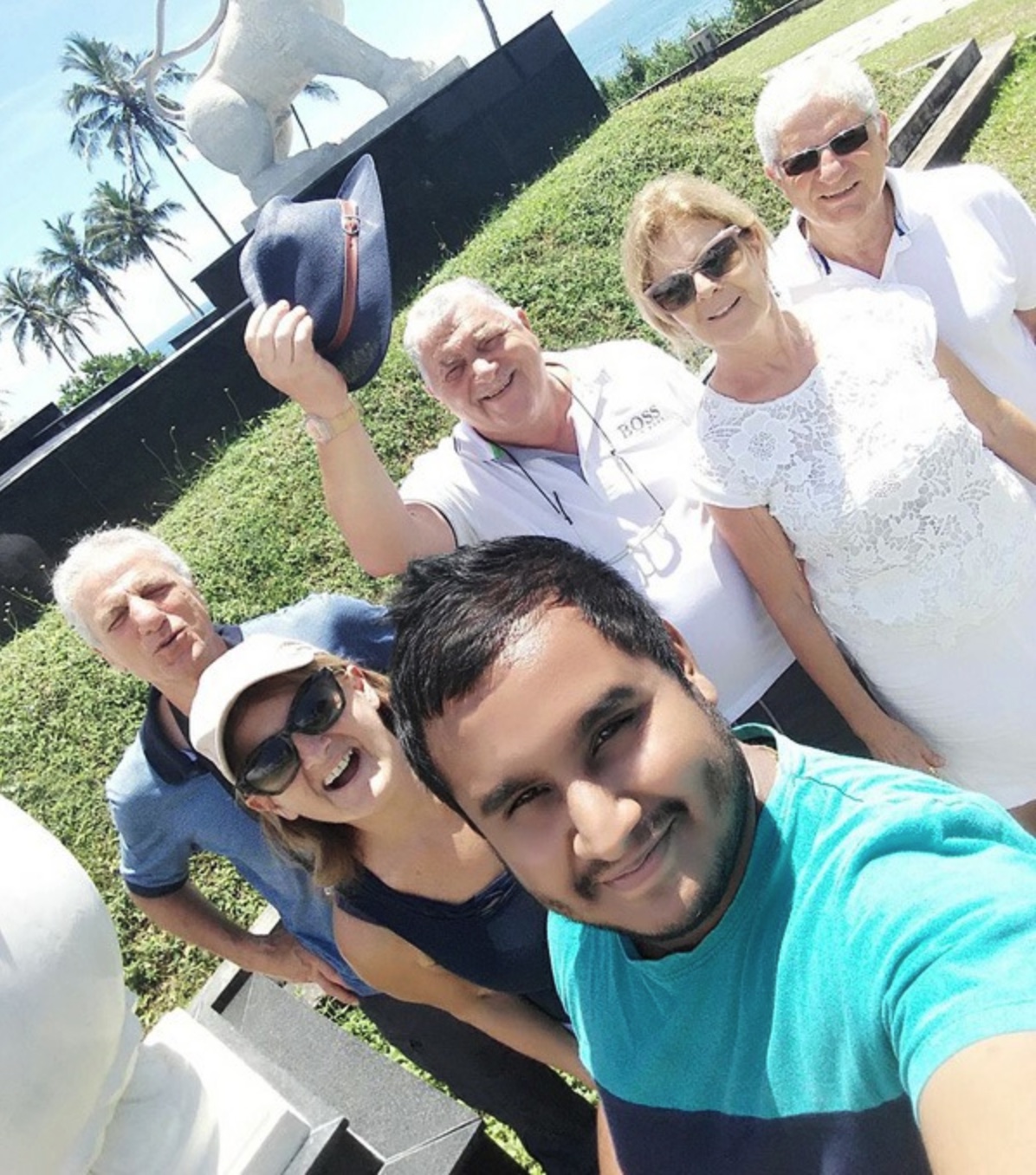 Senior travellers taking a group photograph with their private driver in Sri Lanka